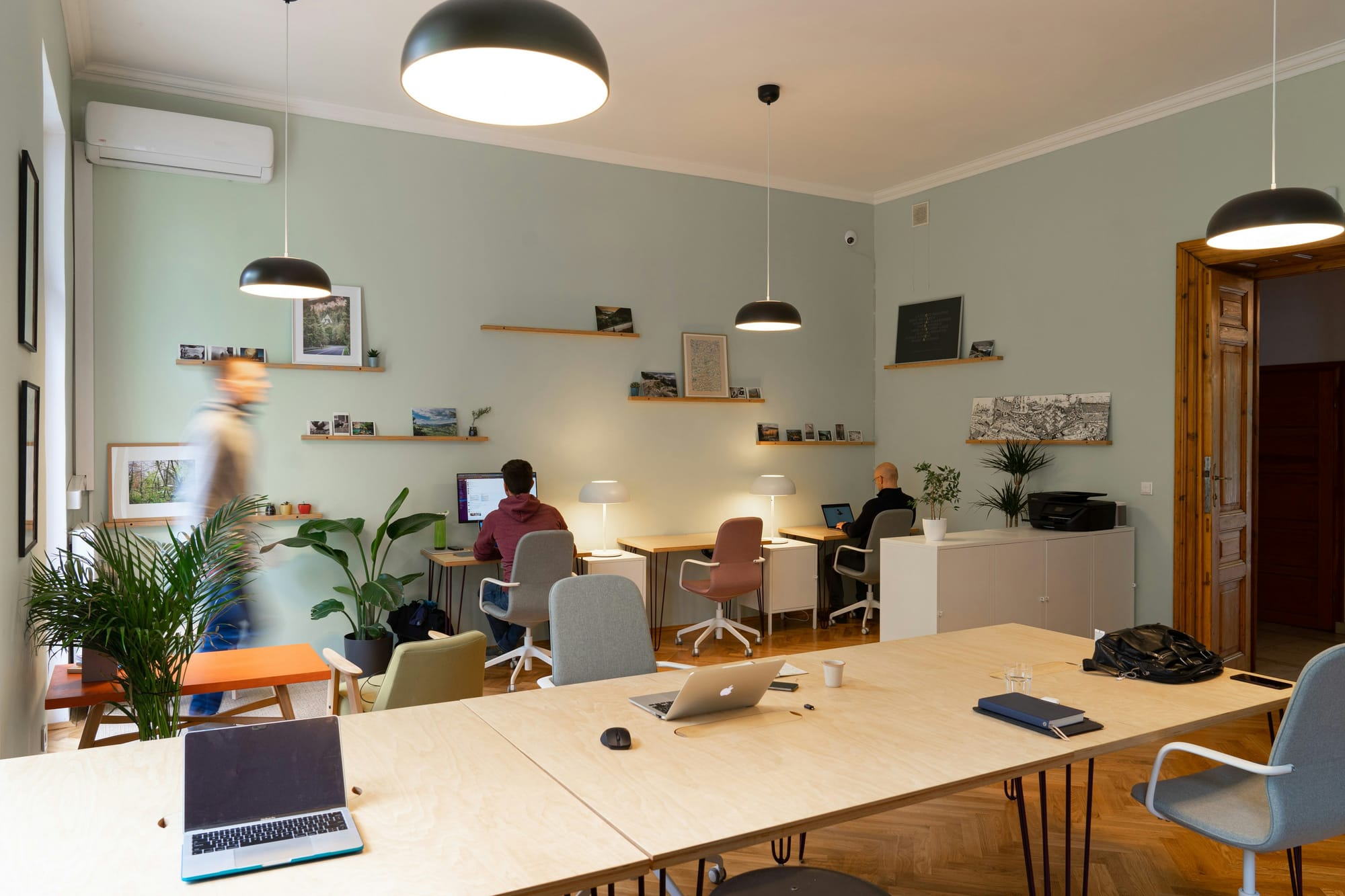 An open-plan office with desks and plants